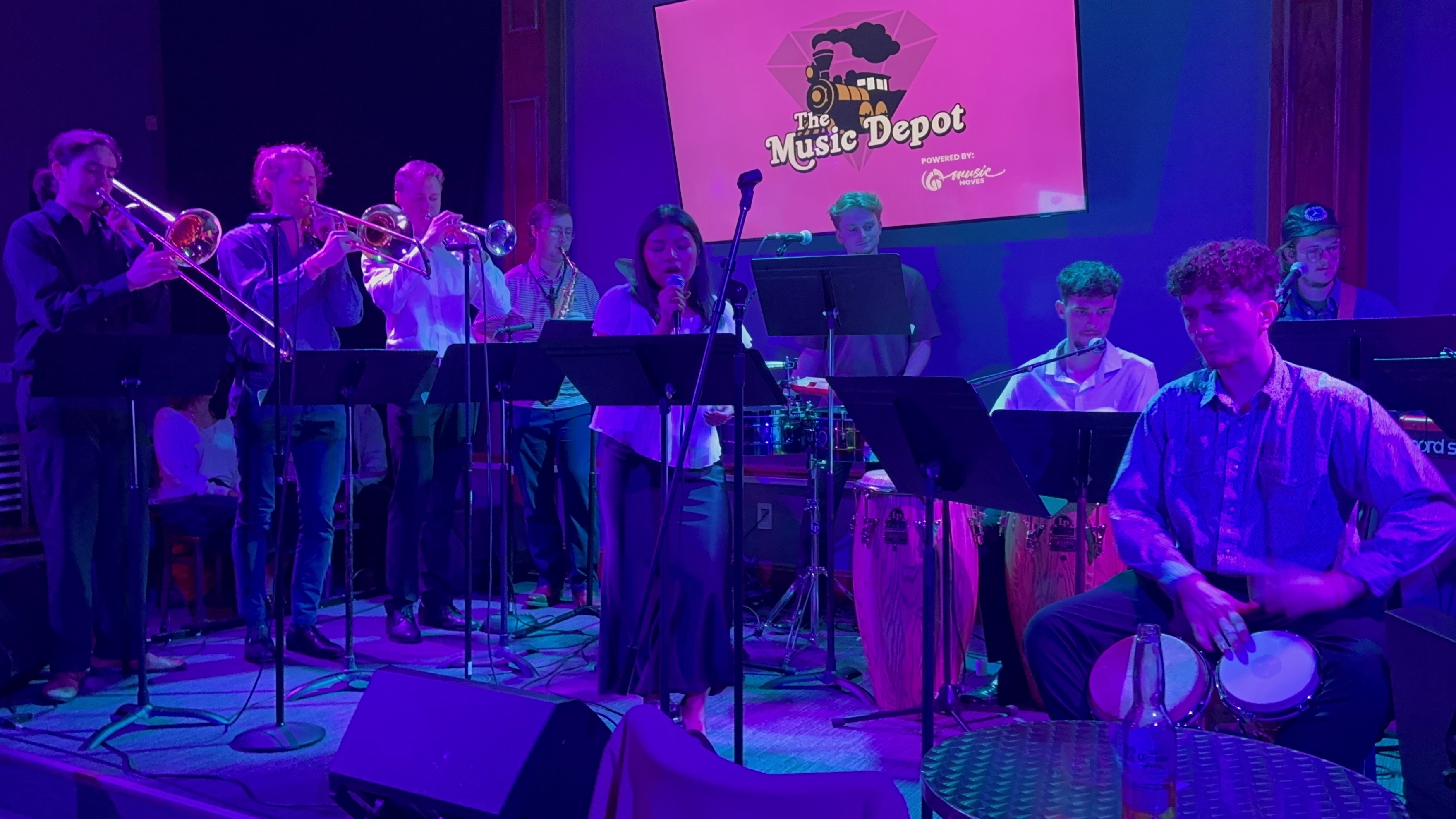The nine members of Orquesta Afinke performing at The Music Depot