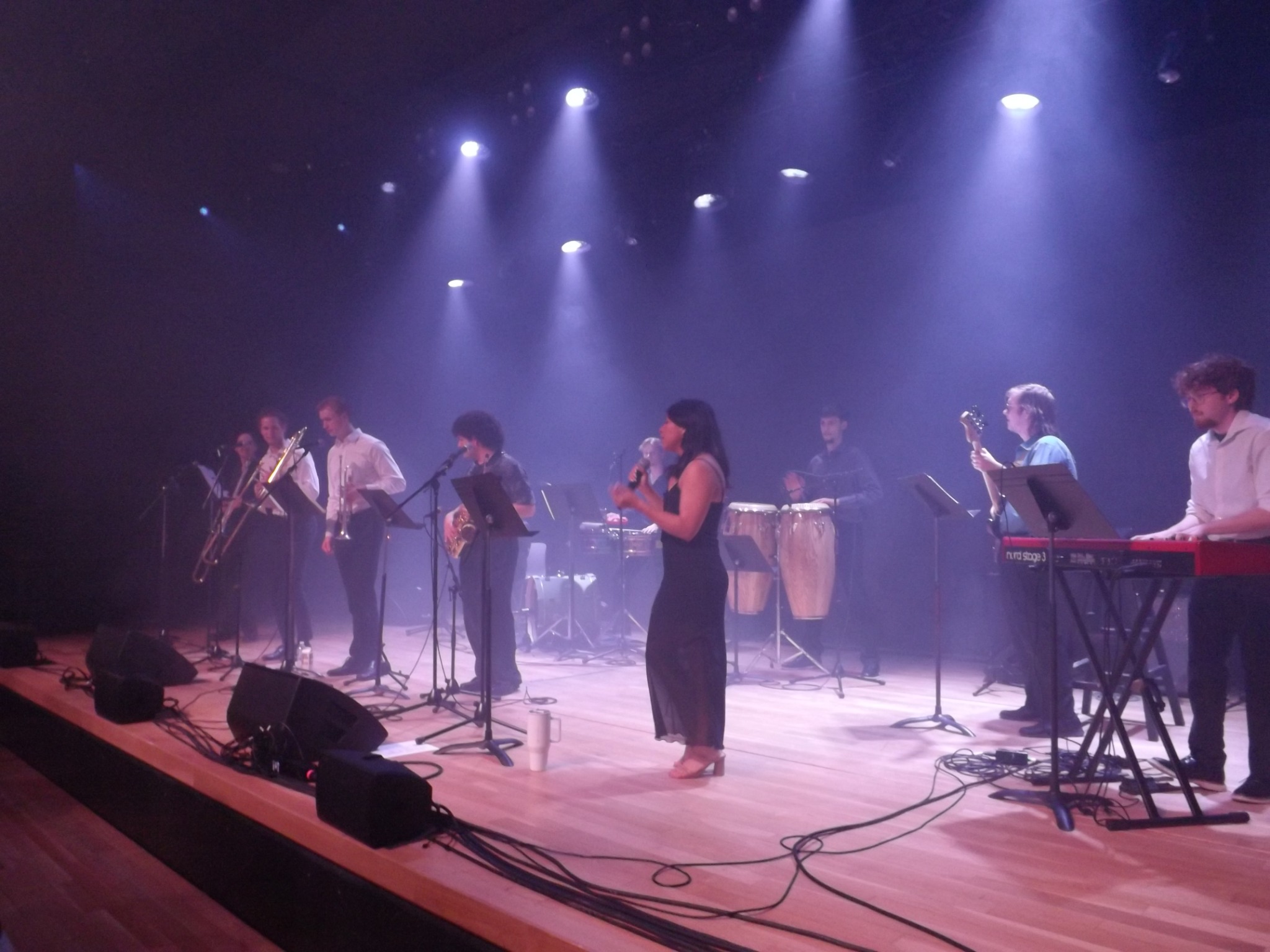 The full Orquesta Afinke lineup performing beneath purple lights